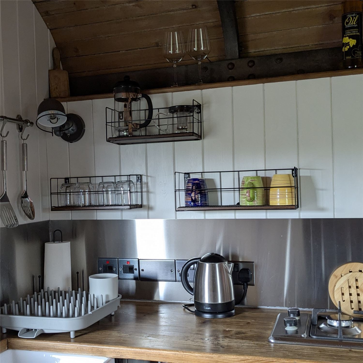Fully equipped kitchen with a small fridge with freezer compartment, two burner hob, oven and prep space